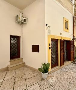 a white building with two doors and a potted plant at Borgo Antico in Grottaglie