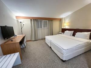 a hotel room with two beds and a flat screen tv at Trakya City Hotel in Edirne +83 photos