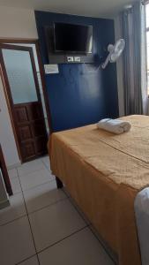 ein Zimmer mit einem Bett und einem Fernseher an der Wand in der Unterkunft Hotel JORGE CHAVEZ in Trujillo