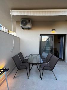 a patio with two chairs and a glass table at DEYA Apartment Becici in Boreti +32 photos