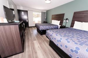 a hotel room with two beds and a television at Scottish Inn Maggie Valley in Maggie Valley +14 photos