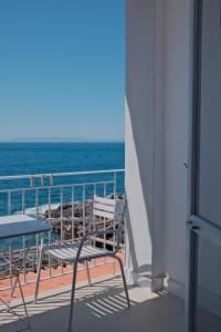a chair and a table on a balcony with the ocean at LELA'S in Kardamyli +11 photos