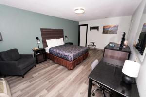 a hotel room with a bed and a chair at Scottish Inn Maggie Valley in Maggie Valley