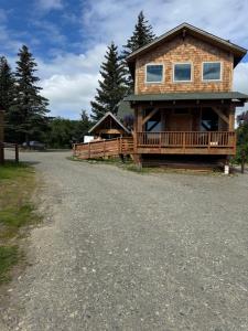 a log home with a porch and a driveway at Rustic Bay View Cabins- Lodge in Homer