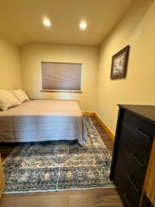 a bedroom with a bed with a window and a rug at Rustic Bay View Cabins- Lodge in Homer
