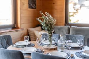 a table with plates and glasses and a vase of flowers at Domek Przy Potoku Murzasichle in Murzasichle +43 photos