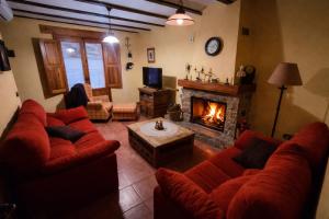 a living room with red couches and a fireplace at Casa rural con terraza en Cabanes - Mar y montaña - Ideal para grupos y familias in Cabanes