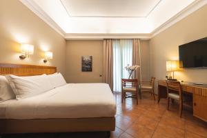 a hotel room with a bed and a desk at Hotel Forum in Pompei