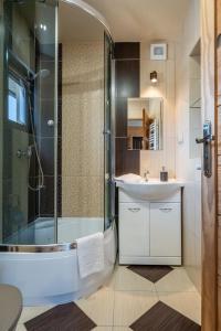 a bathroom with a glass shower and a sink at Domek Przy Potoku Murzasichle in Murzasichle