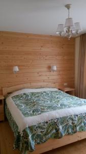a bedroom with a bed with a wooden wall at ZarinSki in Kvasy
