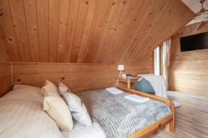 a bedroom with a bed in a wooden room at Domek Przy Potoku Murzasichle in Murzasichle