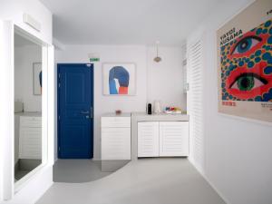 a kitchen with a blue door and white cabinets at Chiara Mykonos in Mikonos
