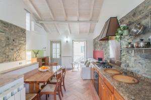 a kitchen with two sinks and a table in a room at Piccola Abbazia by RentAllComo in Lenno +28 photos