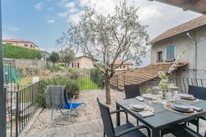 a patio with a table and chairs and a tree at Piccola Abbazia by RentAllComo in Lenno