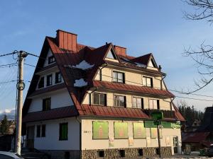 a large house with a gambrel roof at Apartament Rodzinny Deluxe in Poronin