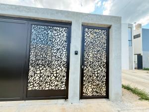 a pair of doors on a building with a gate at Casa completa , dos Habitaciones con baño en cada cuarto in Mérida