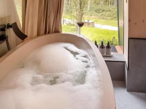 a bathtub filled with snow and a glass of wine at Liberty-Qu7629 in Chipping Norton