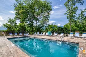 a swimming pool with chairs and blue chairs in it at Bucky's Bungalow, Free Attraction Tickets, Hot Tub, WIFI!!! in Gatlinburg