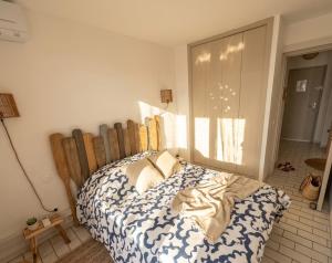 a bedroom with a bed with a wooden headboard at Vue sublime-conciergrie IB in Canet-en-Roussillon