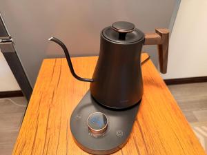 a black tea kettle sitting on a wooden table at -貸切別荘-源泉かけ流し温泉 あずみ野ガレージヴィラ-1日1組限定- in Azumino