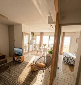 a living room with a couch and a television at Vue sublime-conciergrie IB in Canet-en-Roussillon