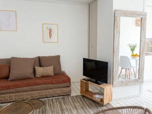 a living room with a couch and a television at Vue sublime-conciergrie IB in Canet-en-Roussillon +10 photos
