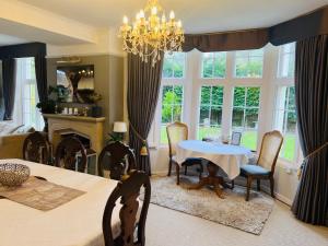a dining room with a table and chairs and a chandelier at The Old Rectory Chicklade in Chicklade
