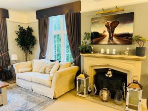 a living room with a couch and a fireplace at The Old Rectory Chicklade in Chicklade