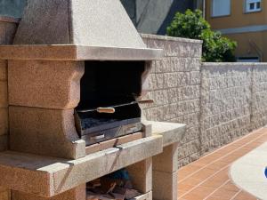 a stone pizza oven sitting on a patio at Apartamento Río Bispo in Bueu