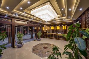 a lobby with potted plants and a large ceiling at Hotel Shanghai City in Osh