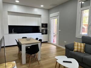 a kitchen and living room with a table and a couch at Apartamento Río Bispo in Bueu +5 photos