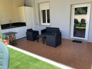 a living room with a couch and chairs and a table at Apartamento Río Bispo in Bueu