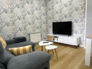 a living room with a couch and a flat screen tv at Apartamento Río Bispo in Bueu