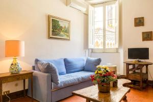 un soggiorno con divano blu e tavolo di SUITE MARINELLA -TAORMINA a Taormina