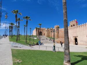 a park with palm trees and a building at Dar Halima in Rabat