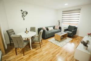 a living room with a couch and a table and chairs at BK Apartman in Zlatibor