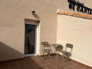 three chairs and a table outside of a building at Casa Rural El Cantarero in Ariza