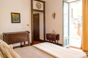 a bedroom with a bed and a mirror and a window at SUITE MARINELLA -TAORMINA in Taormina