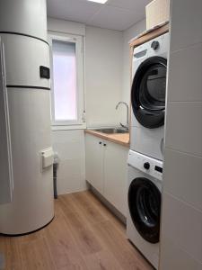 a kitchen with a refrigerator and a washer and dryer at Casa Rural El Cantarero in Ariza