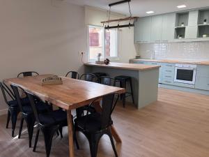 a kitchen with a wooden table and some chairs at Casa Rural El Cantarero in Ariza