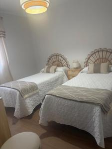 two beds sitting next to each other in a bedroom at Casa Rural El Cantarero in Ariza +13 photos