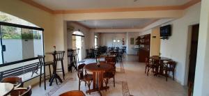 a restaurant with tables and chairs in a room at Canto do Atlântico Hotel in Guarujá