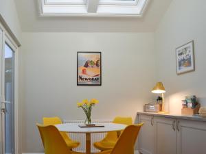 a dining room with a table and yellow chairs at Tolcarne Retreat in Newquay