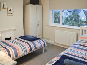 a bedroom with two beds and a window at Tolcarne Retreat in Newquay +11 photos