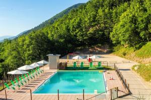 a swimming pool with chairs and umbrellas at APPARTAMENTI Vista del Mondo in Spoleto