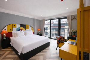 a bedroom with a bed and a desk and a laptop at Hanora Boutique Hotel in Hanoi