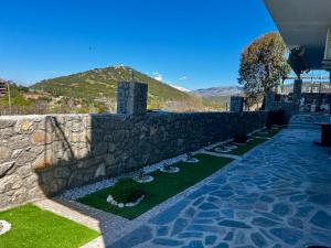 a stone retaining wall with a stone path and grass at Quiet Mountain View Retreat Helicon, Kyriaki in Kiriákion