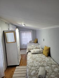 a bedroom with two beds and a refrigerator at Dream Big Bougainvillea 2 bedroom cottage in Centurion