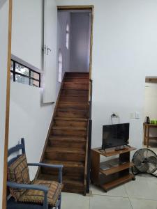 a room with a staircase with a chair and a television at Dream Big Bougainvillea 2 bedroom cottage in Centurion