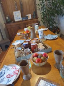 a table with bowls of apples and other food on it at Au chat qui pêche in Pléguien